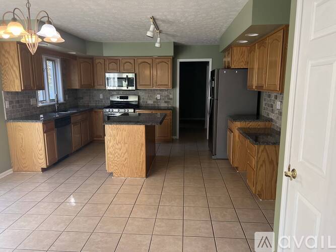 A kitchen with wooden cabinets and a tiled floor.