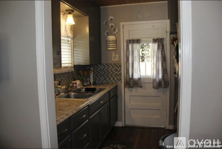 A kitchen with a sink and a door.