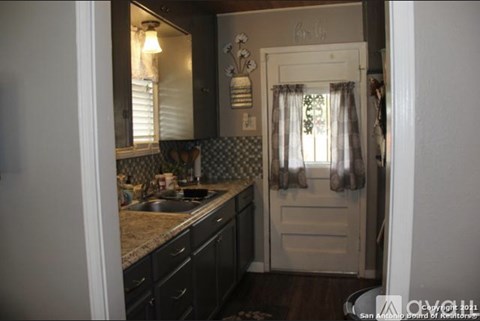 A kitchen with a sink and a door.