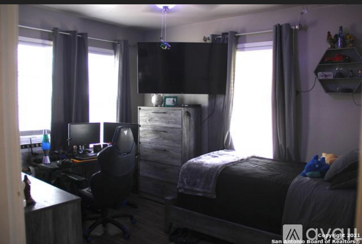 A bedroom with a bed, desk, and chair.