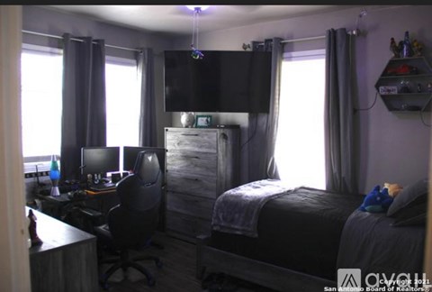 A bedroom with a bed, desk, and chair.