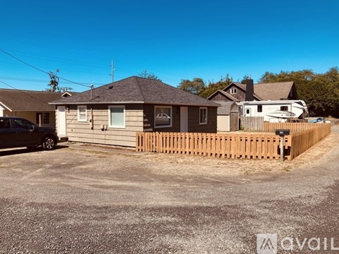 A house with a wooden fence is available for rent.