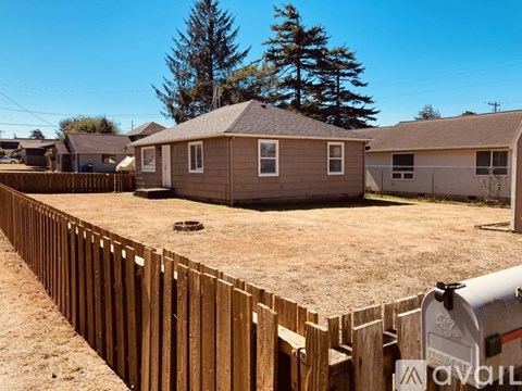 A backyard with a wooden fence and a mailbox.