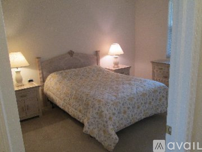 A bedroom with a bed, nightstands, and lamps.