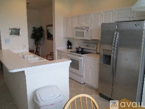 A kitchen with white cabinets and appliances.