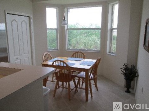A dining room with a table and chairs.