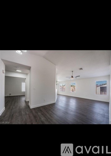 A spacious room with wooden floors and white walls.
