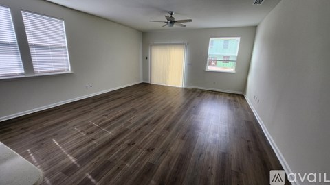 A room with wooden flooring and a ceiling fan.