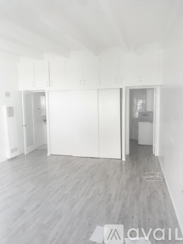 A spacious room with white cabinets and a grey floor.