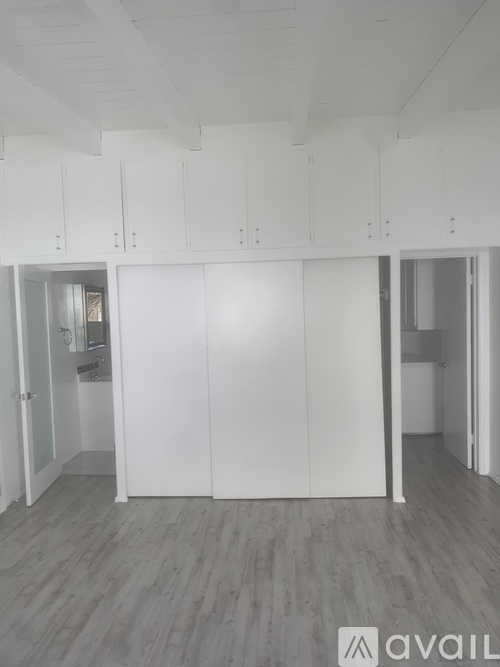 A room with white cabinets and grey flooring.