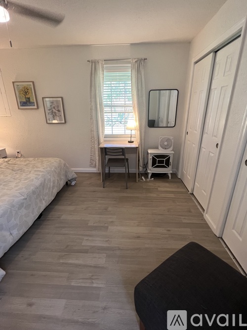 A bedroom with a bed, desk, and chair.