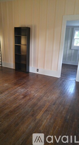 A room with wooden floors and a cabinet.