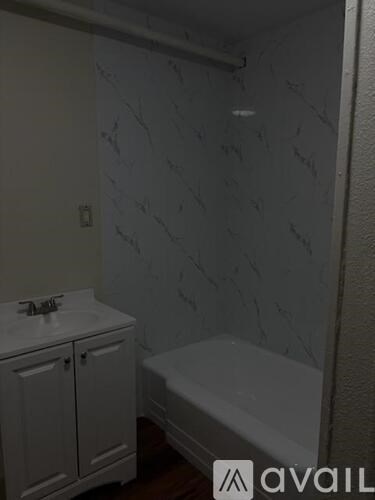 A bathroom with a white tub and sink.