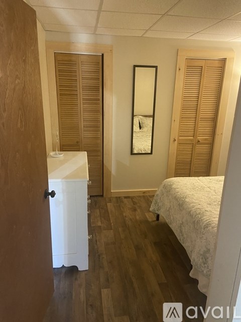 A bedroom with a bed, dresser, and mirror.