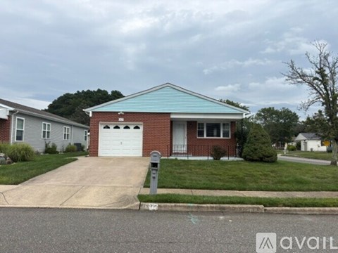 A house with a blue roof and a white garage door is for sale.