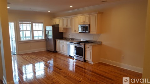 A kitchen with wooden floors and white appliances.