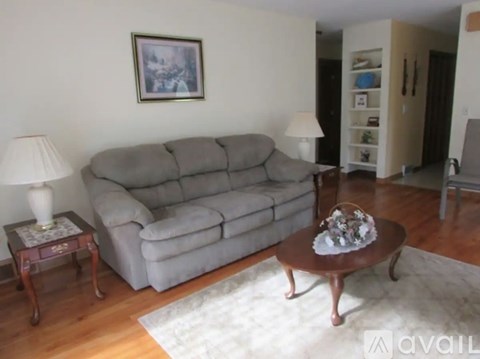 A grey couch sits in a living room with a table in front of it.