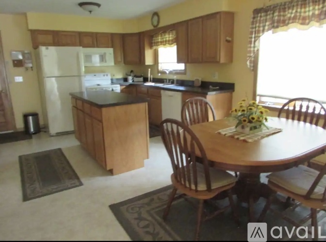 A kitchen with a table and chairs in the middle of the room.