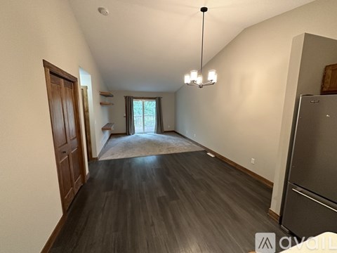 A spacious room with wooden floors and a large window.