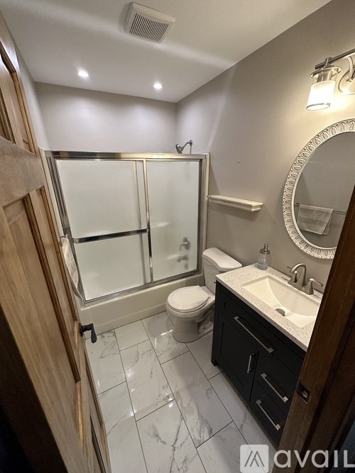 A bathroom with a sink, mirror, toilet, and shower.