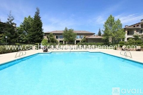 A swimming pool in front of a row of houses.