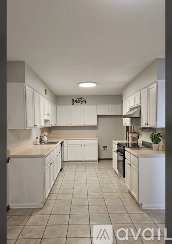 A kitchen with white cabinets and a tiled floor.