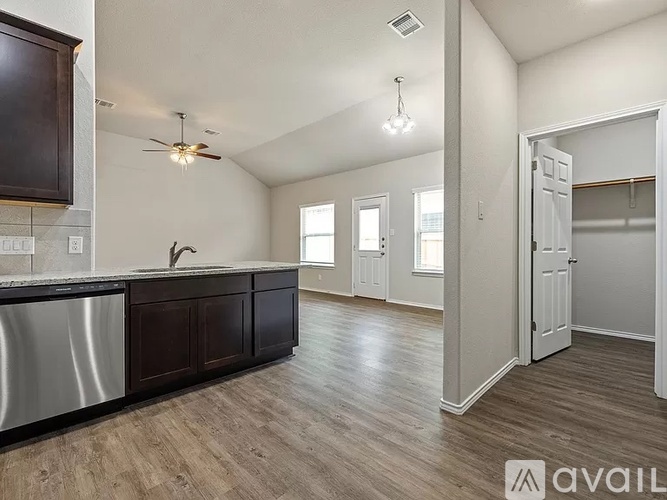 A kitchen with dark brown cabinets and a white counter top.