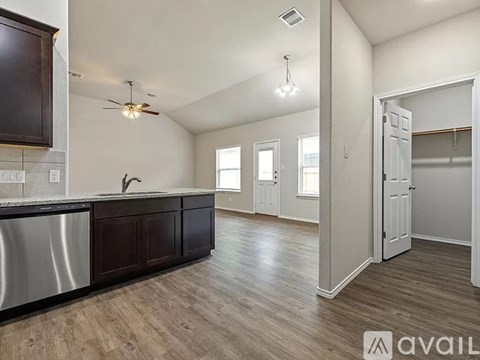 A kitchen with dark brown cabinets and a white counter top.