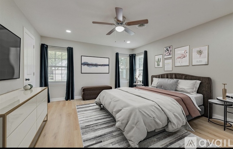 A bedroom with a large bed and a ceiling fan.
