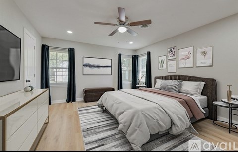 A bedroom with a large bed and a ceiling fan.
