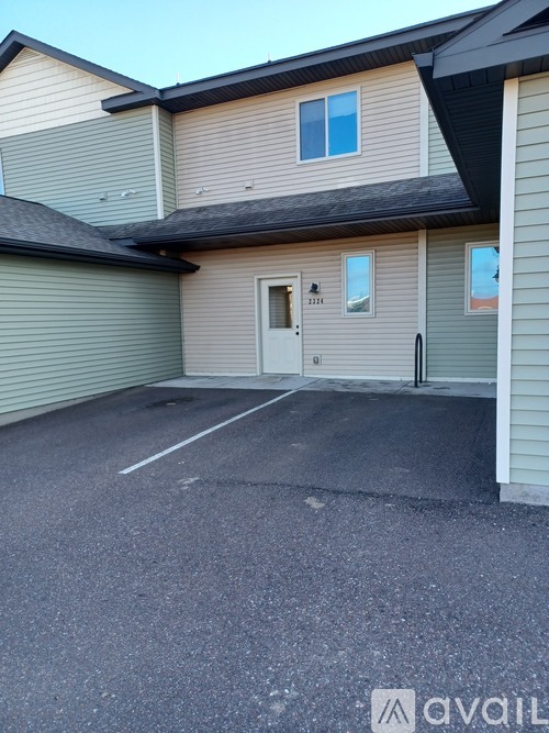 A house with a garage and a driveway in front of it.