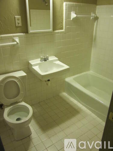 A bathroom with a toilet, sink, and bathtub.
