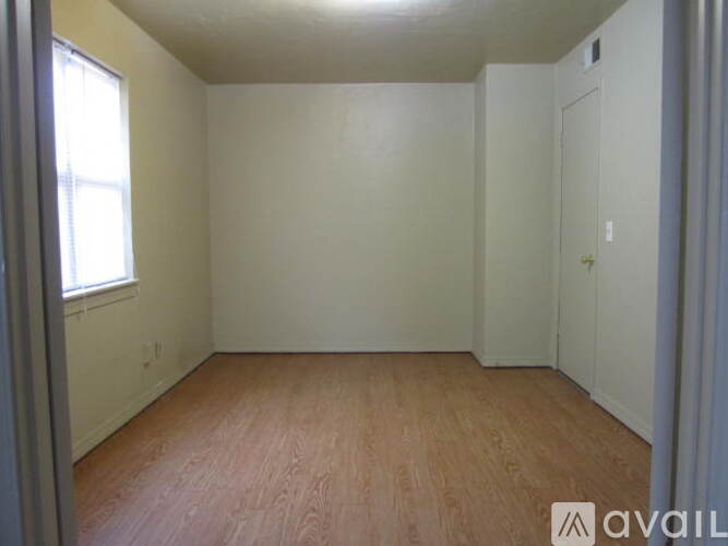 Empty room with wooden floor and white walls.