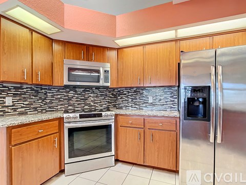 A kitchen with wooden cabinets and a stone backsplash.