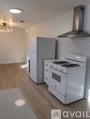 A modern kitchen with a white stove and refrigerator.