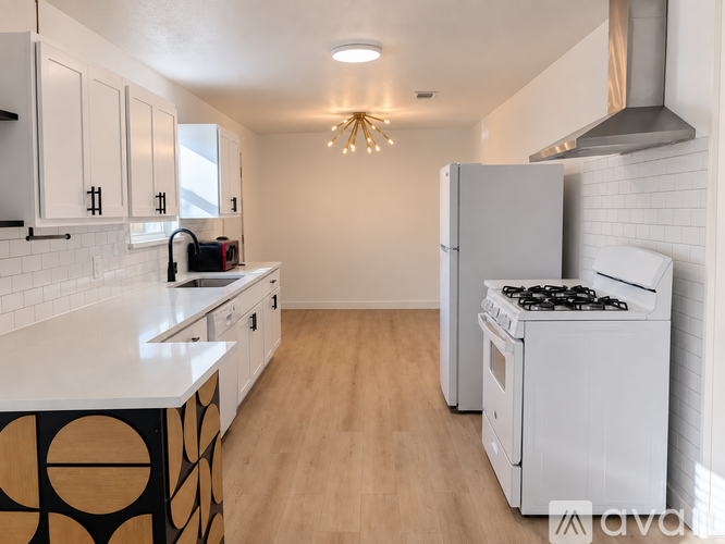 A kitchen with white cabinets and a white stove.