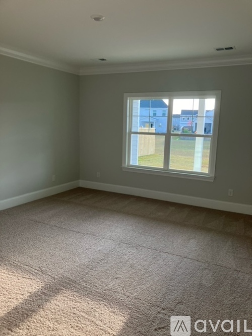 A room with a carpeted floor and a window.