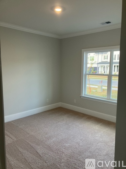 A room with a carpeted floor and a window.