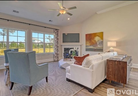 A living room with a grey chair, a white sofa, and a television.