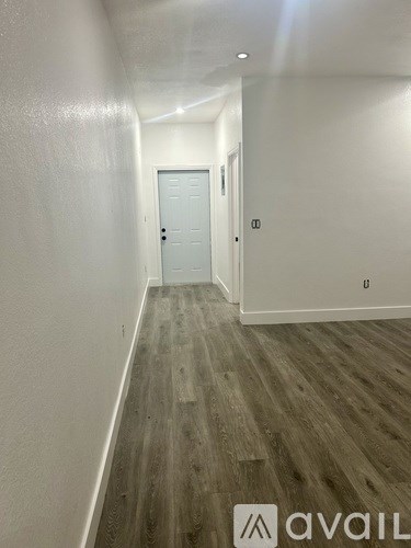 A hallway with a door and Avail logo.