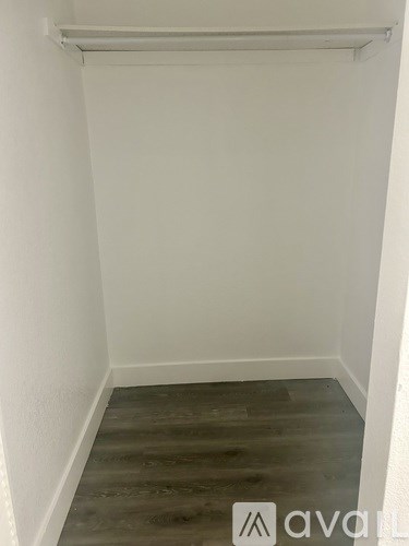 A small room with wooden flooring and white walls.