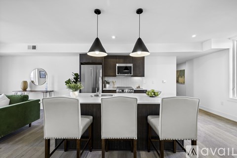 A modern dining room with a dark wood table and white chairs.