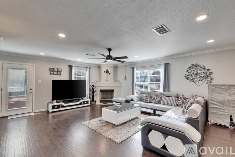 A living room with a television, a fireplace, and a sofa.