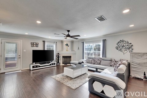 A living room with a television, a fireplace, and a sofa.