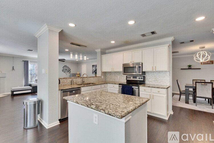 A kitchen with granite countertops and white cabinets.