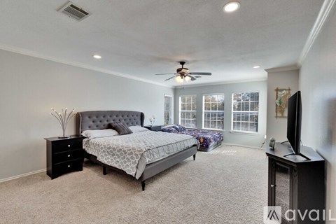 A bedroom with a bed, dresser, and television.