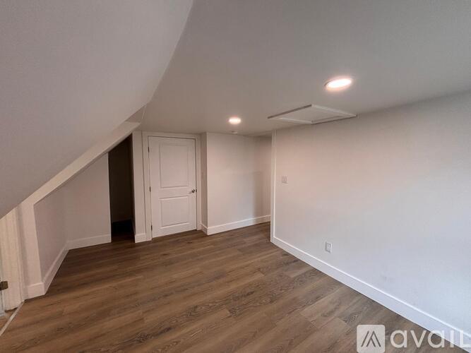 A room with wooden flooring and a white door.