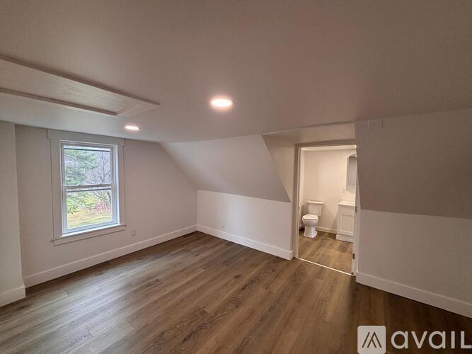 A room with wooden flooring and a window.