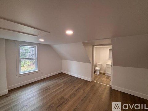 A room with wooden flooring and a window.