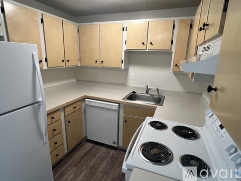 A kitchen with a white refrigerator, a white dishwasher, and a white stove top oven.